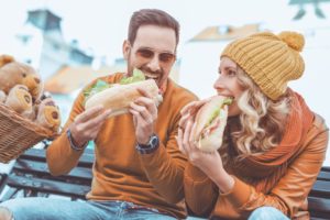 couple eating sandwich while travelling