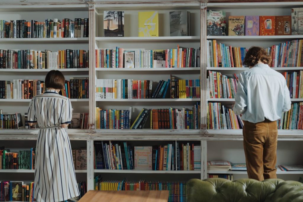 man and woman reading by the bookshelf