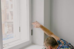 person measuring a window